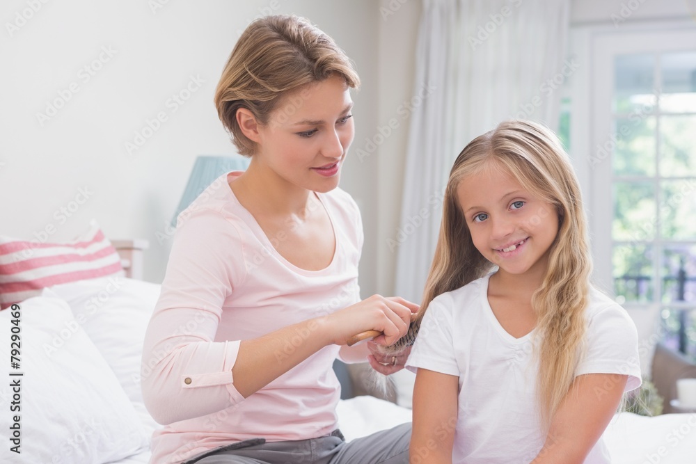 Mother brushing her daughters hair Mother brushing her daughters hair