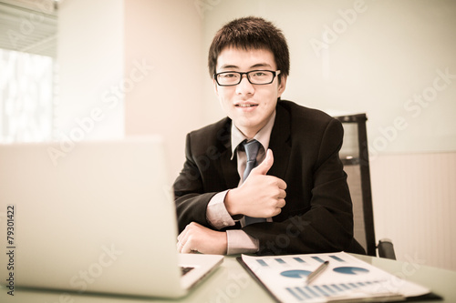 Young handsome man using laptop in his office