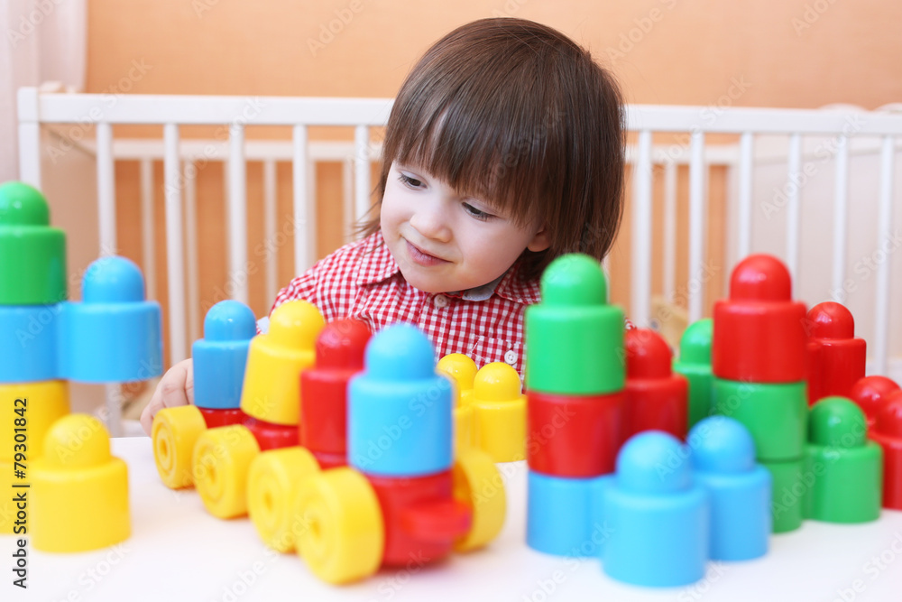 happy little boy playing plastic blocks happy little boy playing plastic blocks