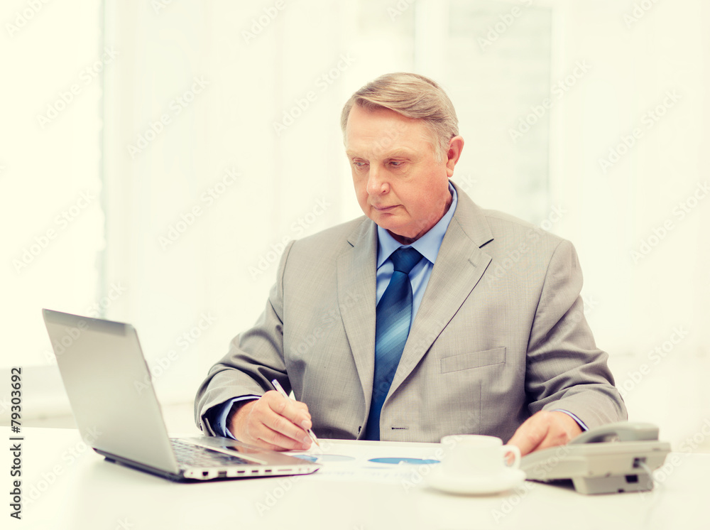 busy older businessman with laptop and telephone busy older businessman with laptop and telephone