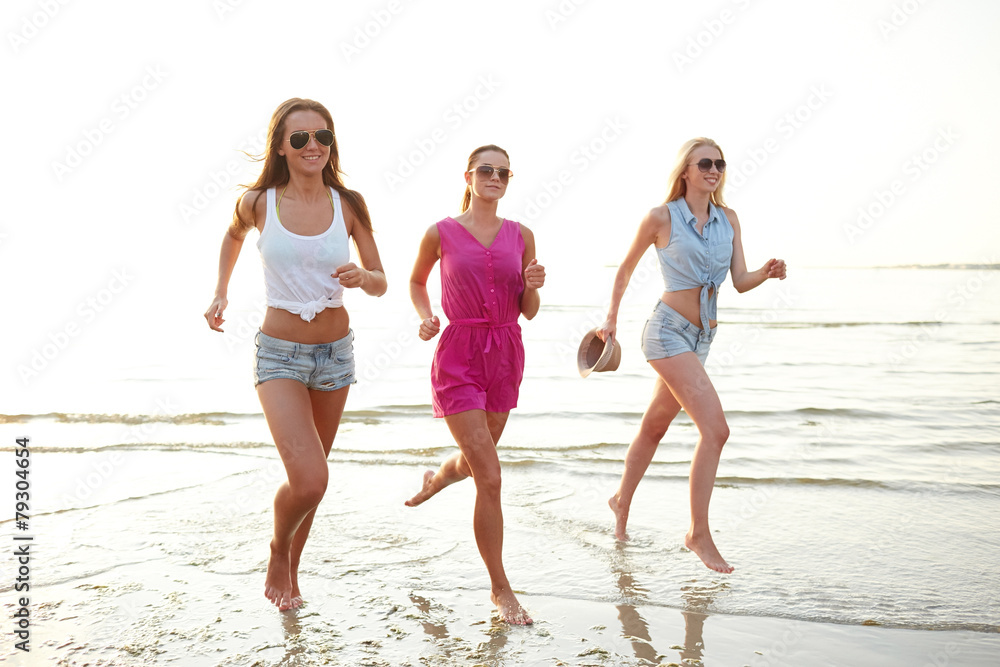 group of smiling women running on beach group of smiling women running on beach