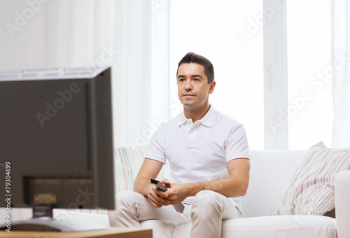 man with remote control watching tv