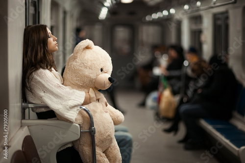 Girl with bear in a subway car. photo