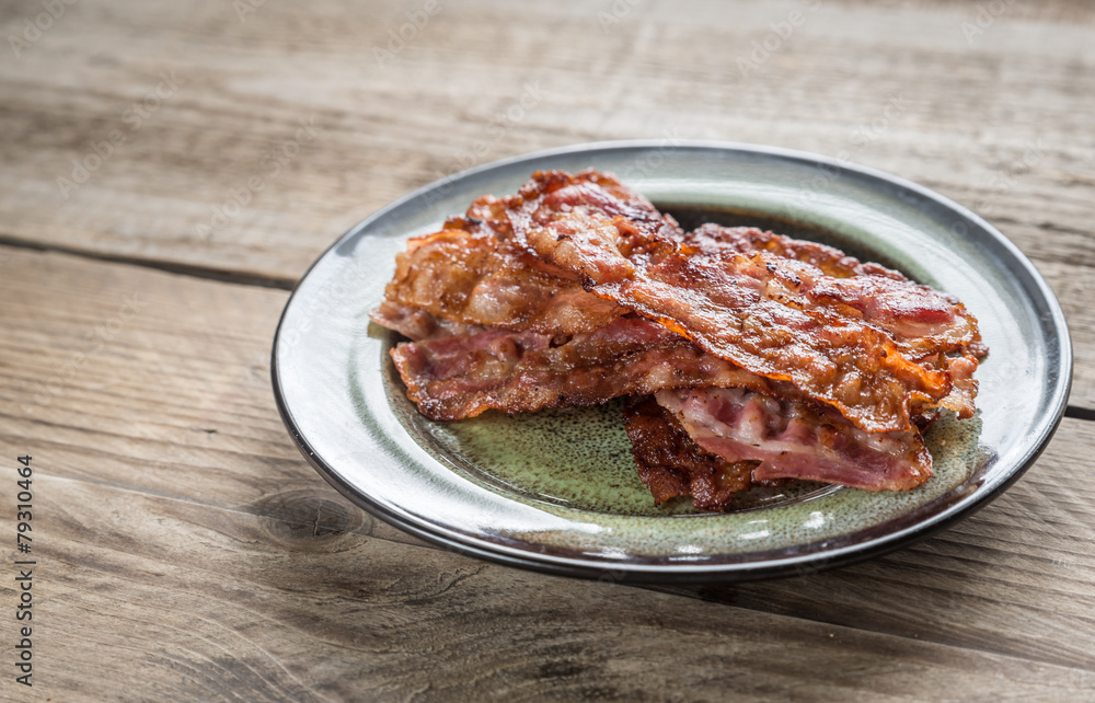 Stack of fried bacon strips on the plate