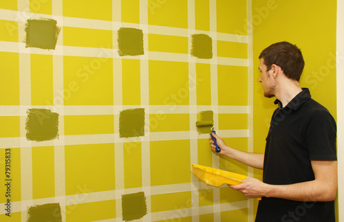 Wormer Man painting wall with masking tape