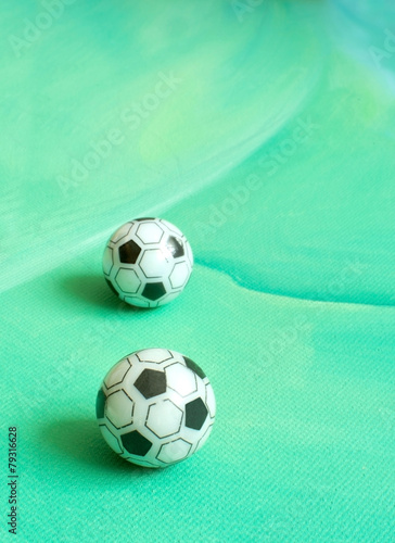 Fototapeta Naklejka Na Ścianę i Meble -  Toy soccer footballs on green canvas background.
