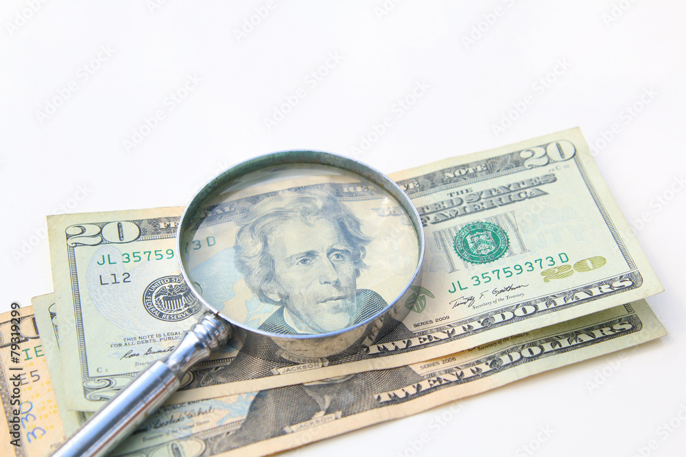 money under magnify glass isolated over white money under magnify glass isolated over white