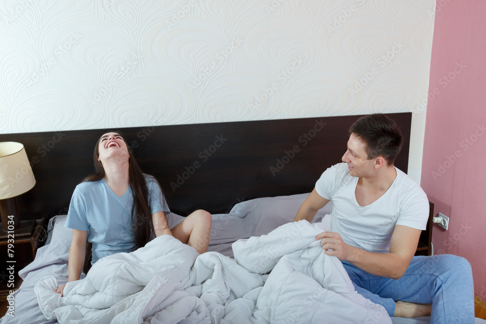 Fototapeta premium Young cute caucasian couple, man and woman in bed smiling