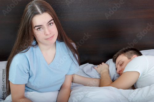 Tableau sur toile Dissatisfied beautiful young woman in bed with sad expression on