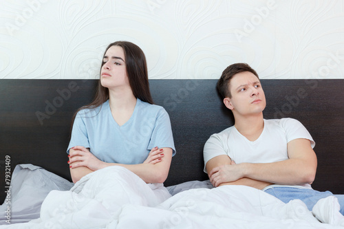 Upset and angry man and woman sitting next to each other