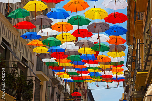 Colorful umbrellas installed on the street in Spanish city.