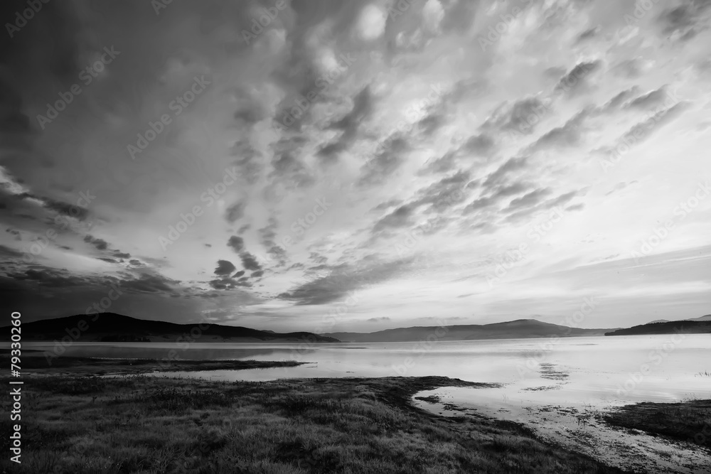 black and white landscape with dramatic sky over the high mountain lake 