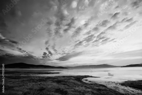 black and white landscape with dramatic sky over the high mountain lake 