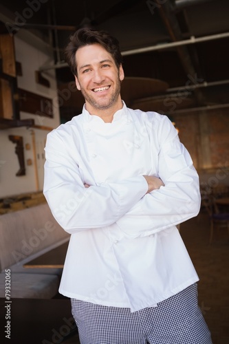 Smiling baker standing with arms crossed