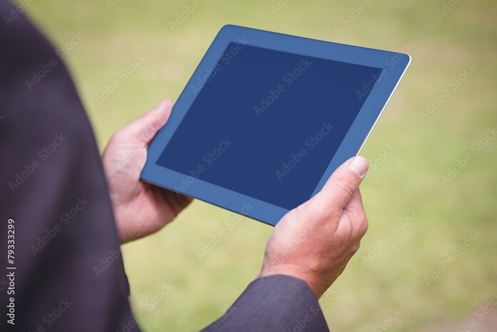 Businessman holding tablet in the park