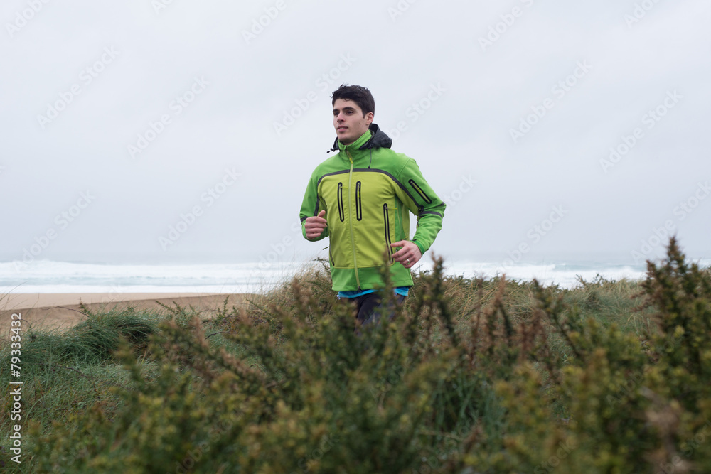 Caucasian runner man running in the beach.
