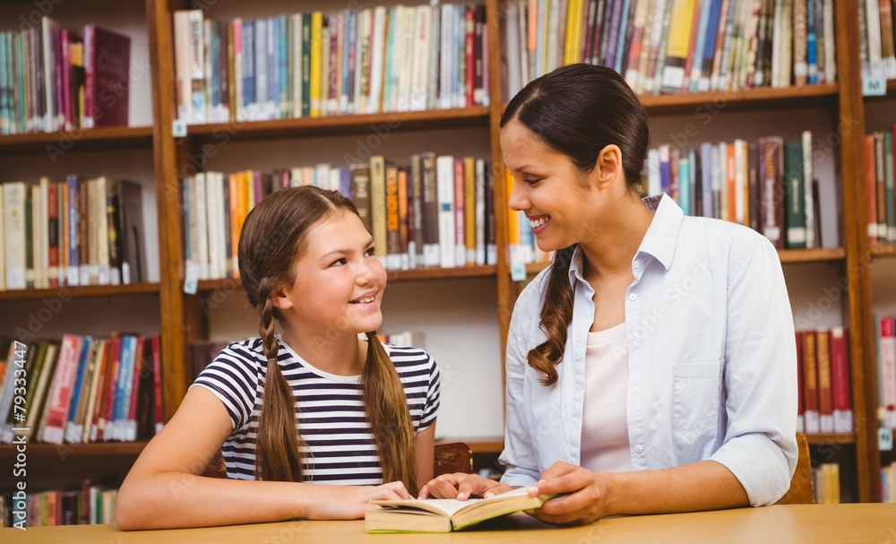 Teacher and girl reading book in library Teacher and girl reading book in library