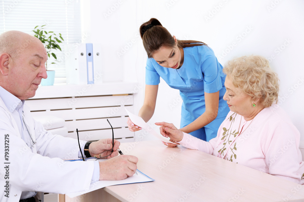 Obraz premium Happy doctors and patient in hospital clinic