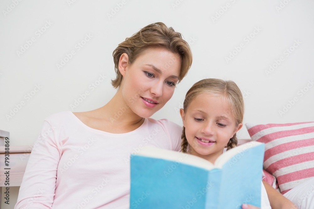 Mother reading her daughter bedtime story Mother reading her daughter bedtime story