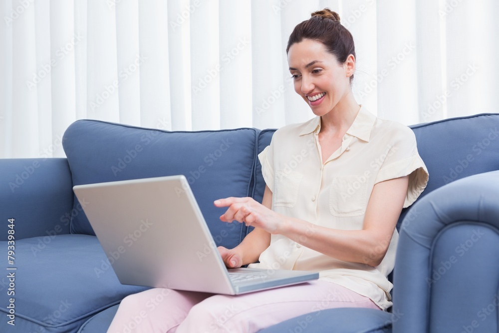 Fototapeta premium Casual brunette using laptop on couch