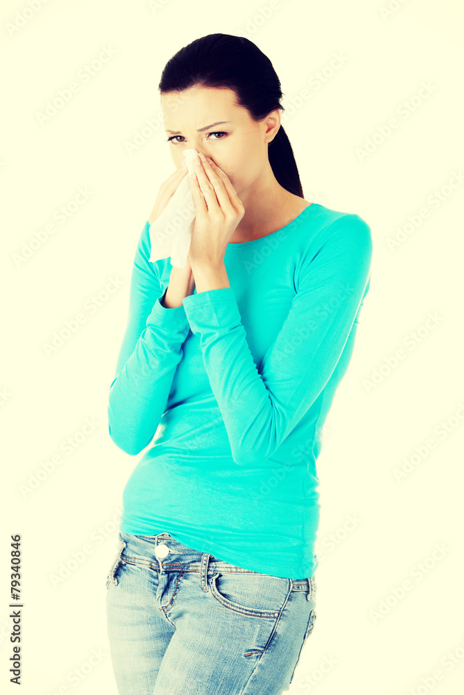 Brunette sneezing in a tissue. Brunette sneezing in a tissue.