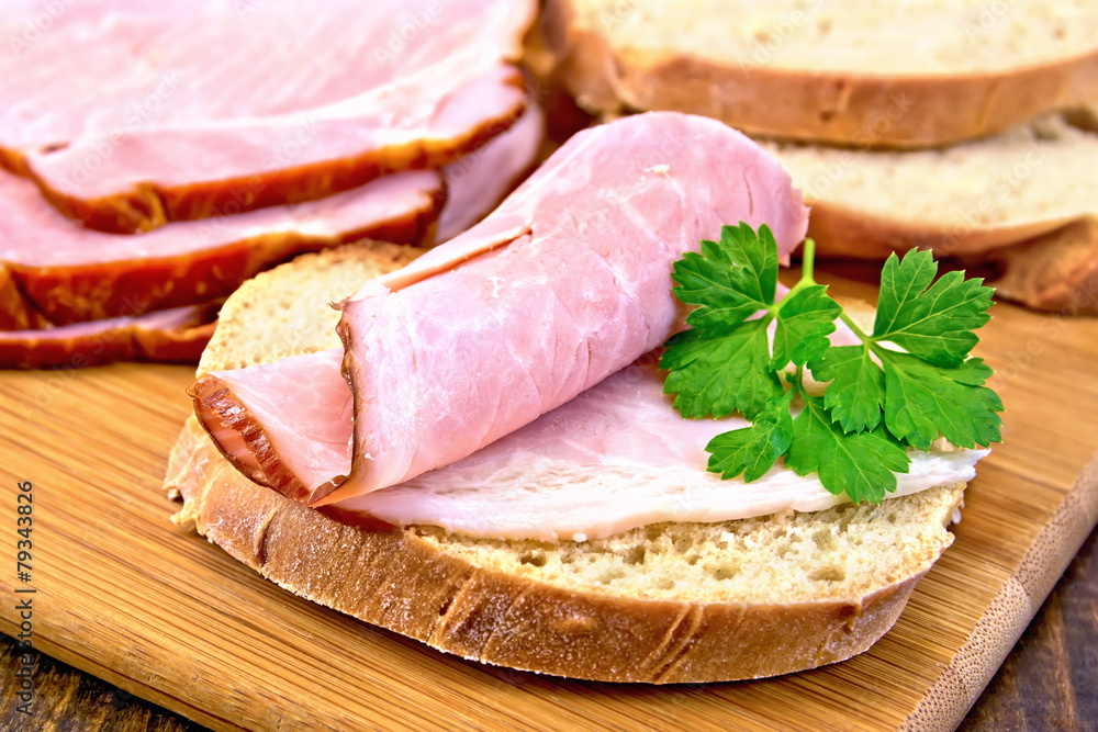 Sandwich with ham and parsley on board
