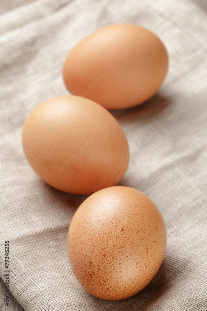 whole raw brown eggs closeup on wood table whole raw brown eggs closeup on wood table