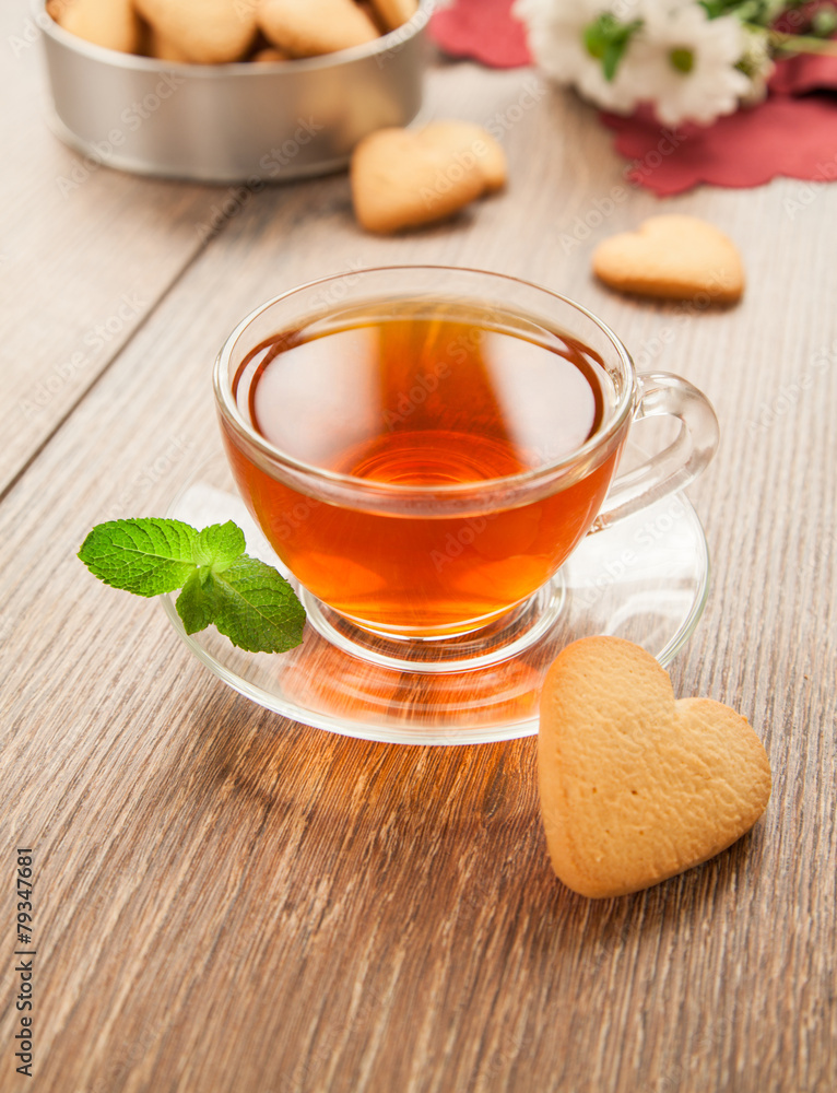 Glass cup of tea on a wooden table.