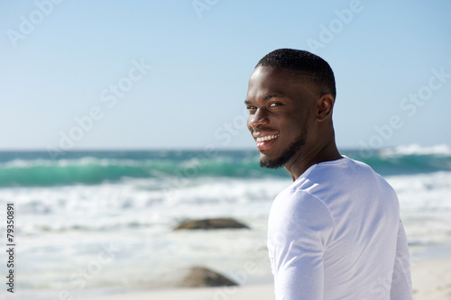 Happy smiling african american man at the beach