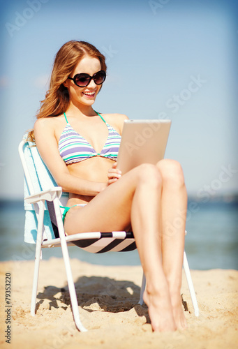 girl looking at tablet pc on the beach