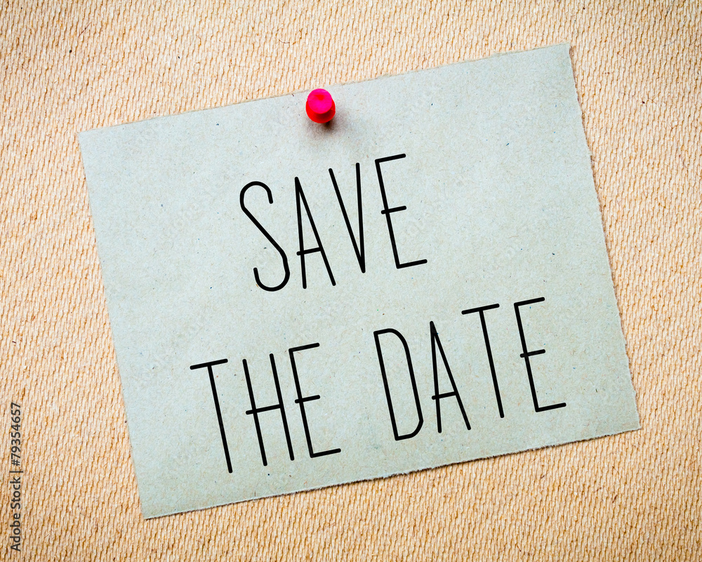 Recycled paper note pinned on cork board.Save the Date Message.