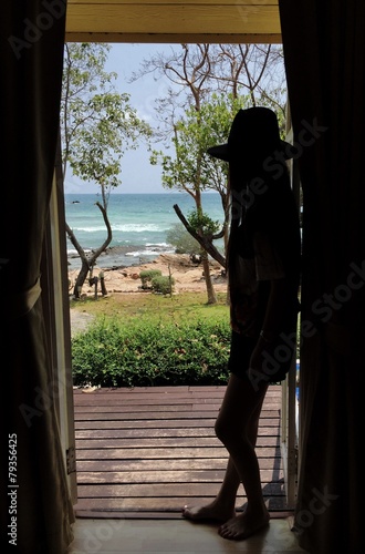 shadow of girl at the door looking to ocean. 