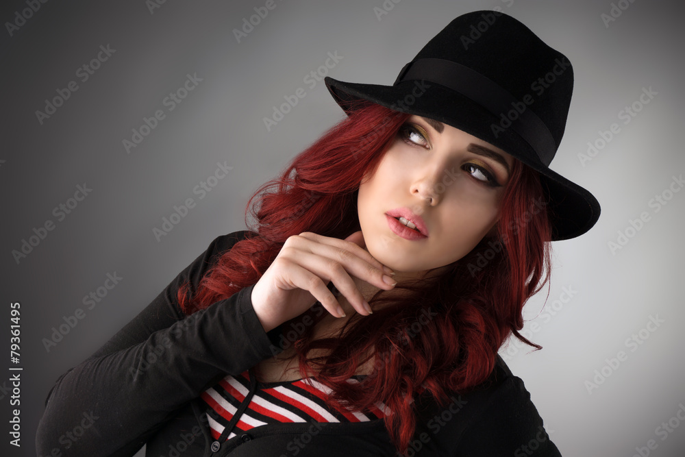 Young redhead woman wearing a hat and posing in the studio Young redhead woman wearing a hat and posing in the studio