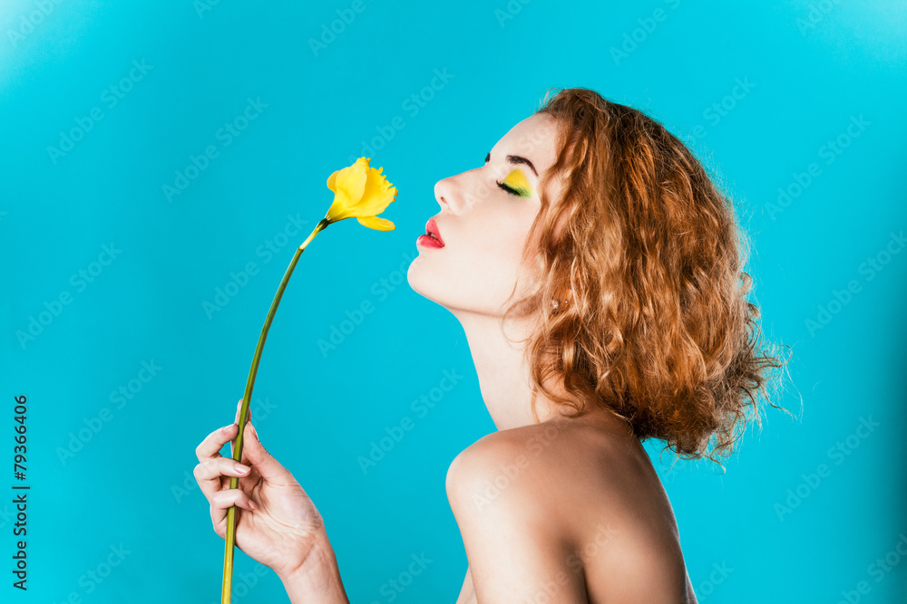 Portrait of a pretty girl with a yellow flower