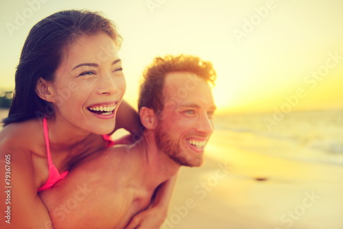 Happy beach fun multicultural couple - summer love © Maridav