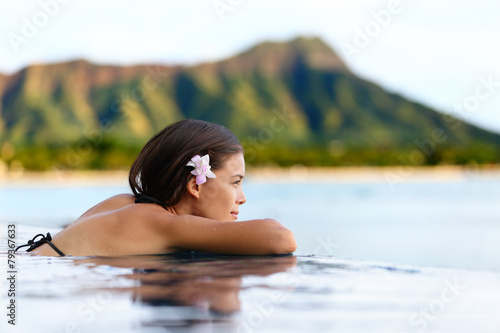 Infinity pool resort woman relaxing at beach