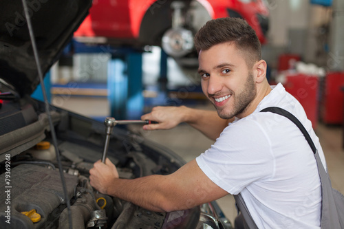 Smiling mechanic using a ratchet wrench