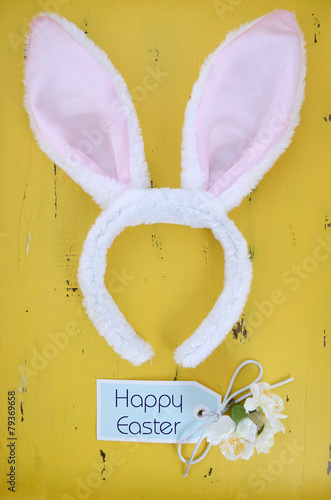 Easter bunny ears on yellow wood background. photo