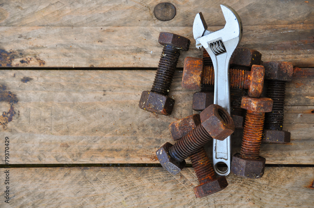 Old bolts with adjustable wrench tools on wooden background. Old bolts with adjustable wrench tools on wooden background.
