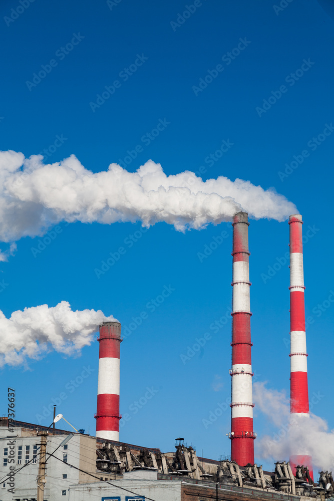 Smoking chimneys against the blue sky