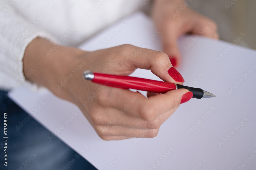 Female hand writing on a sheet of paper Female hand writing on a sheet of paper