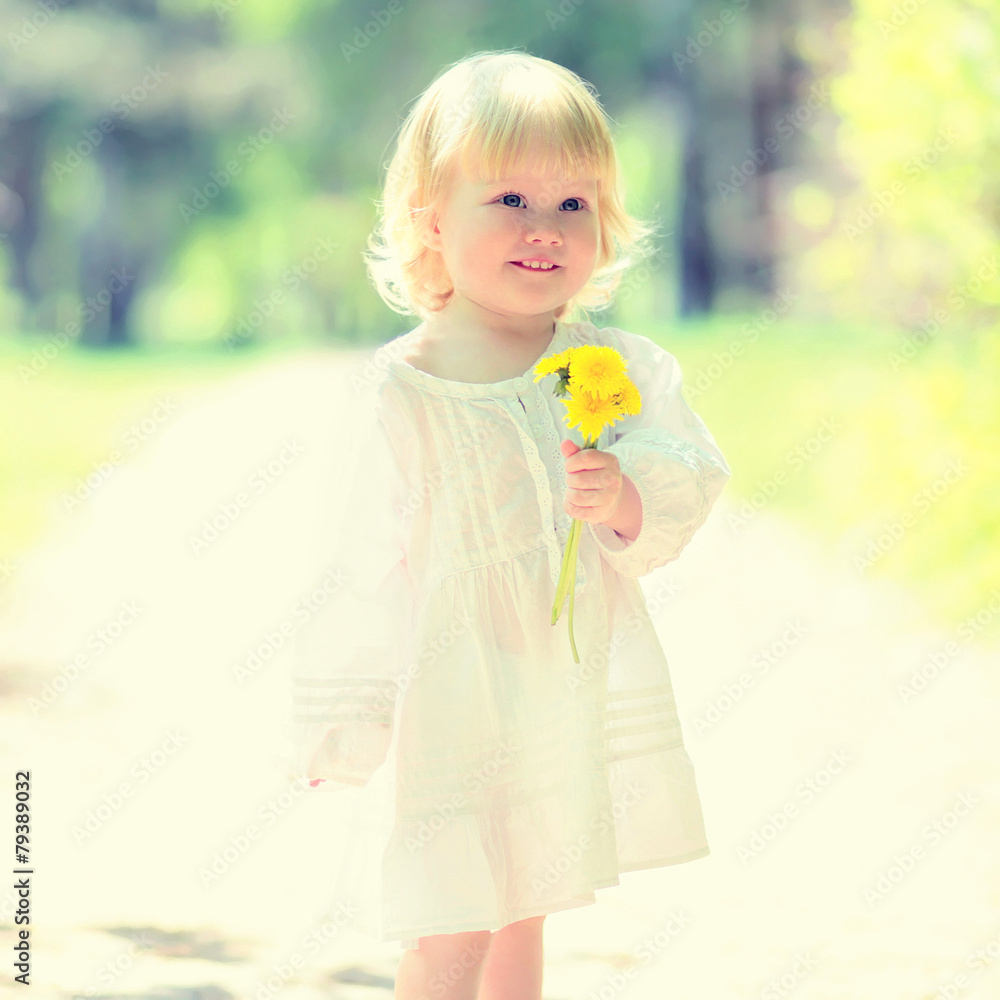 Sunny portrait of cute child with yellow dandelion in summer day Sunny portrait of cute child with yellow dandelion in summer day