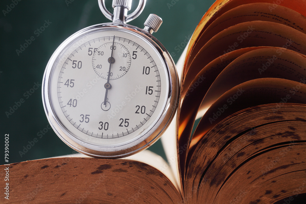 Obraz premium stopwatch resting on top of the open book