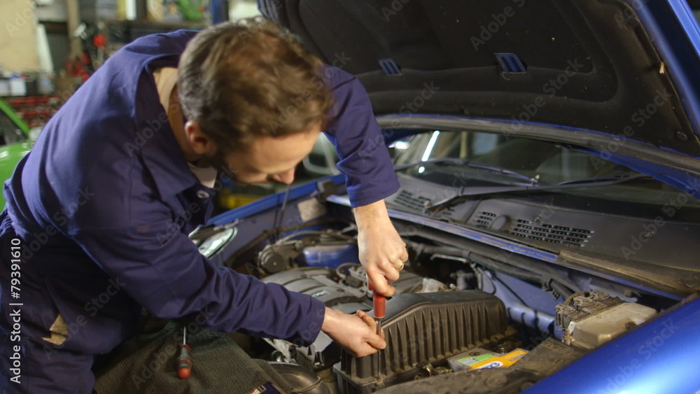 Portrait of a mechanic repairing a car engine in a garage Portrait of a mechanic repairing a car engine in a garage