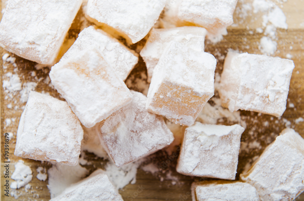 oriental sweets in powdered sugar on wooden board oriental sweets in powdered sugar on wooden board