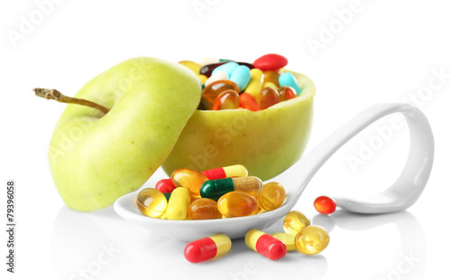 Apple and colorful pills  isolated on white