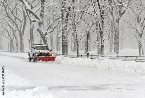 Truck with snowplow clearing road during snowstorm © nyker