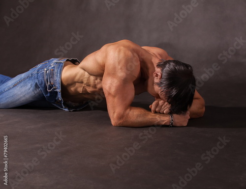 Bodybuilder lying on the floor in the studio