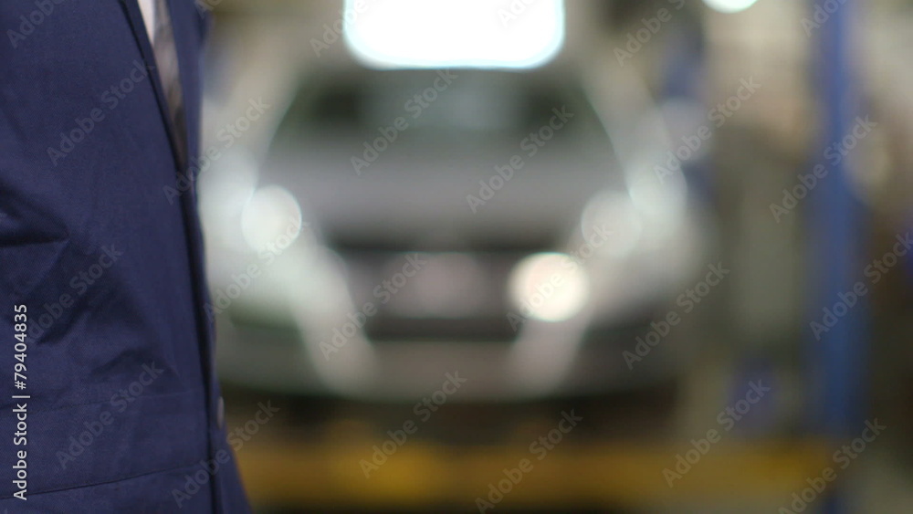 Close Up shot of mechanic and customer shaking hands in an auto repair shop. Close Up shot of mechanic and customer shaking hands in an auto repair shop.