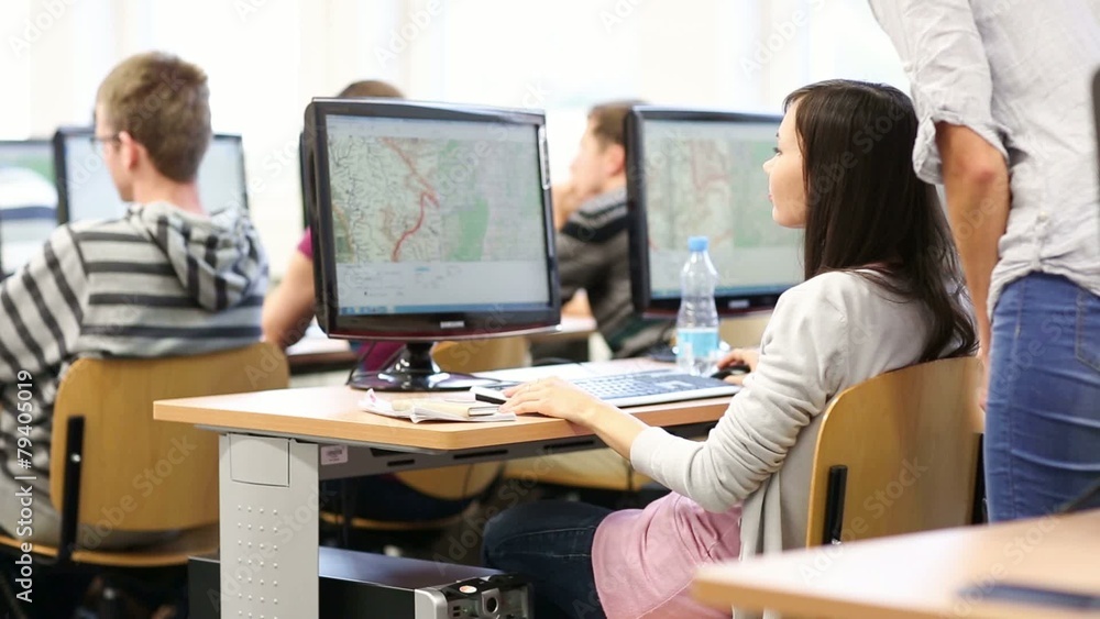 College students sitting in a classroom, using comput College students sitting in a classroom, using comput